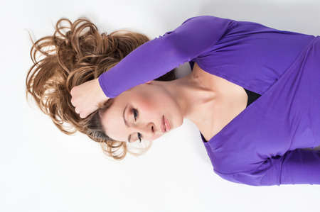 Portrait of a beautiful woman in purple leggings and top posing on a white background. Lite make-upの写真素材