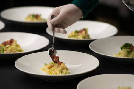 Closeup of chief serving Irish colcannon with bacon served in a white bowl or traditional mashed potato with addition of kale, leek and green onion, close-upの写真素材