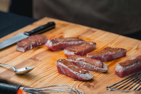 chef in a restaurant making a dish from tuna steak on a wooden plankの写真素材