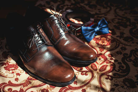 Businessman accessories. Men's Accessories: Men's bowtie, shoes and belt. Grooms Set in the sunlightの写真素材