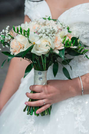 Beautiful wedding bouquet in hands of the brideの写真素材