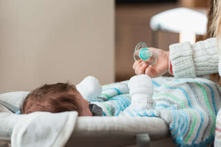 Baby Hand holds a pacifier as a baby item for reassuranceの写真素材