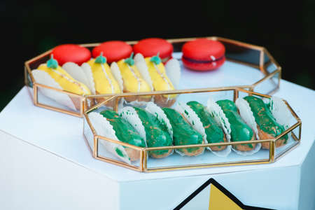 Group of french delicious colorful dessert Eclair on glass tray.の写真素材