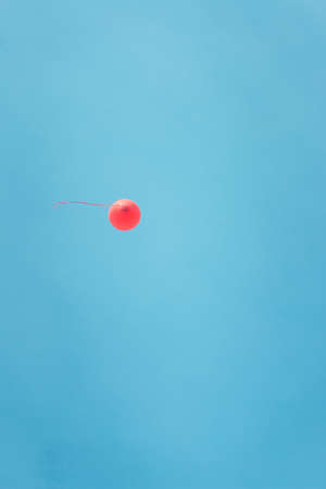 simple red balloon i flying in the blue sky.