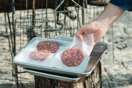 Beef and Pork Patty for Burger. Cooking Cutlets on Mangal. Grill Minced Meat. Chef Cooks burger in street outdoors. Summer Picnic in Nature. Tasty Meat Dish. Closeupの写真素材