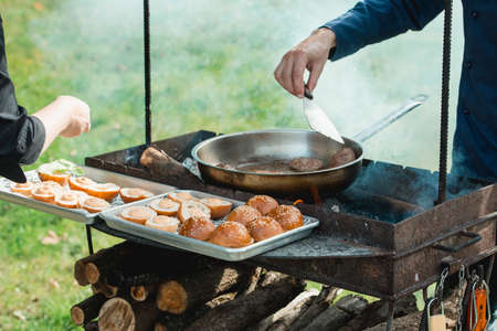 Beef and Pork Patty for Burger. Cooking Cutlets on Mangal. Grill Minced Meat. Chef Cooks burger in street outdoors. Summer Picnic in Nature. Tasty Meat Dish. Closeupの写真素材