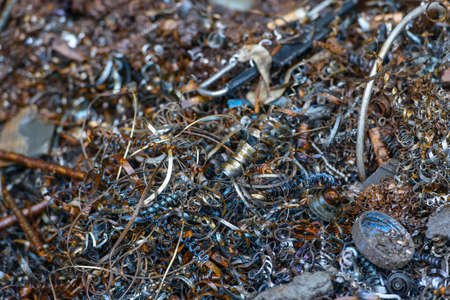 Steel scrap materials recycling. waste after machining metal parts on a cnc lathe. twisted spiral steel shavings. Small roughness sharpnessの写真素材