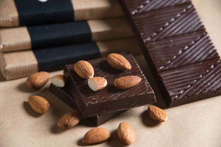 Homemade chocolate bar with almond on craft paper background. Concept of healthy homemade sweetsの写真素材