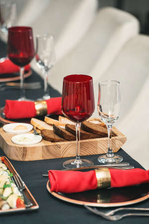 Table served for Christmas dinner in red colors in a restaurant, close up viewの写真素材