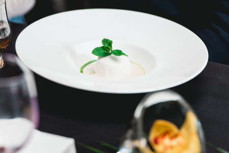 coconut dessert with sorbet, gourmet dessert on a white plate in a restaurant.の写真素材