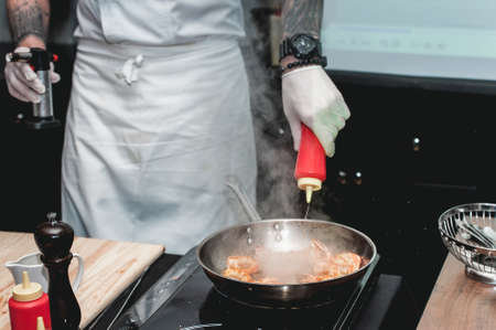 Shrimp on frying pan. Thermal processing of food. Electric cooker in a restaurant. The chef is going to make Spicy Shrimp Tacosの写真素材
