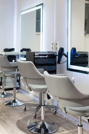 Workplace for haircut in barbershop, with backlit mirror. stylish chairsの写真素材