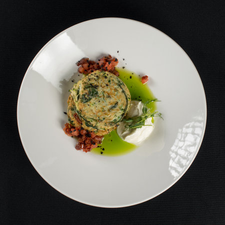 Zucchini pancakes served with sun-dried tomatoes and cream cheese on a black tableclothの写真素材