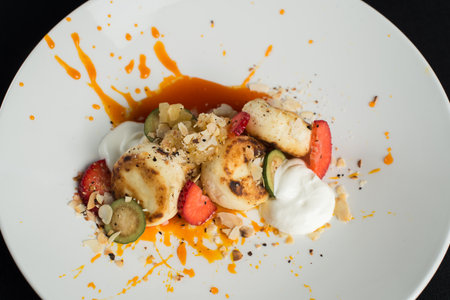 Cottage cheese pancakes with sour cream and almond flakes and sea buckthorn-orange sauceの写真素材