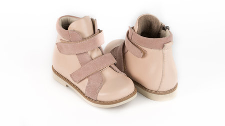 childrens beige high orthopedic lacing shoes on a white backgroundの写真素材