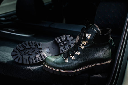 High womens or unisex shoes. Pair of boots with shoe laces. Modern youth fashion of womens casual footwear. Dark green glossy leather shoes.の写真素材