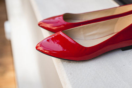 Leather red womens shoes on a white wooden shelf. Fashion, minimal fashion concept, womens shoes, accessories. red womens lacquered leather shoesの写真素材