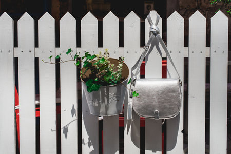 Festive evening small silver bag on a white rustic fence. Luxury accessories and party concept.の写真素材