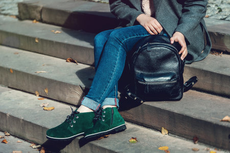 young stylish woman walking in autumn city, cold season, wearing leather backpack, fashion trendの写真素材