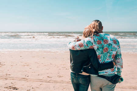 Vacation couple walking on beach together in love holding around each other. Happy interracial young coupleの写真素材
