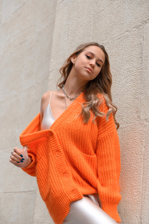 Portrait of fashionable women in orange sweater and beige sweater posing in the streetの写真素材