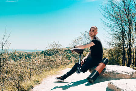 a man on a prosthetic leg travels the mountains. Dressed in black jeans and a T-shirt