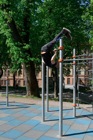 athletic young man with artificial leg working out on a barsの写真素材