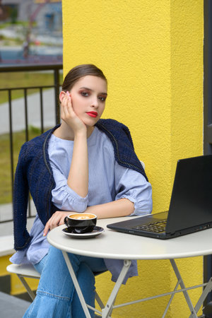 Charming happy woman student using laptop computer to prepare for the course work.の写真素材
