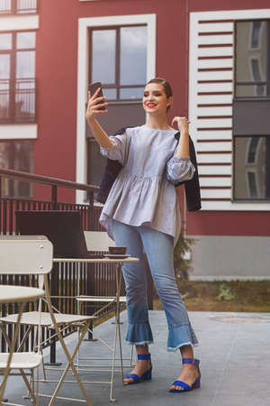 Charming happy woman student communicates by video call and use laptop computer to prepare for the course work.の写真素材