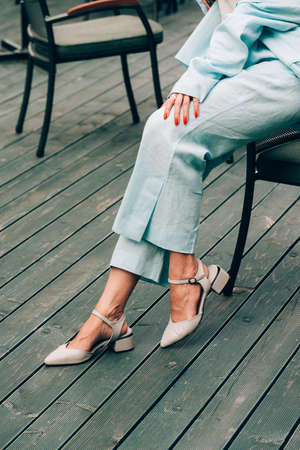 female legs in blue cotton pants and beige shoesの写真素材