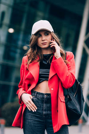 A woman on the street uses a mobile phone.の写真素材