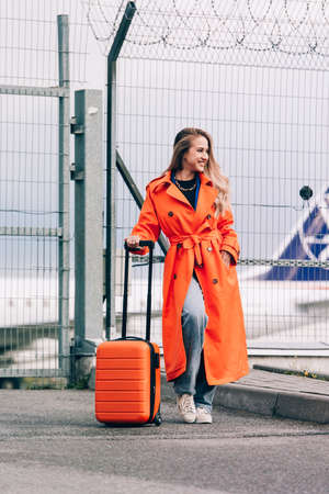 happy woman walking near airport, with luggage. Air travel, summer holidayの写真素材