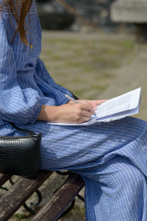 Female hand with pen completing personal information on form.の写真素材