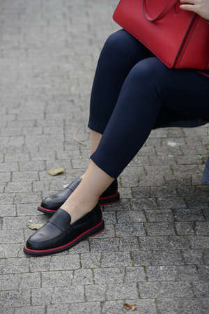Female fashion concept. Womans legs in a black shoes with red lineの写真素材