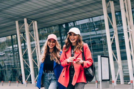 Two happy girls walking near airport. Air travel, summer holidayの写真素材