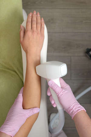 Laser hair removal on ladies hand. woman in beige lingerie
