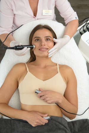 Non injection mesotherapy. Doctor and patient in clinic. Rejuvenation cosmetology tool. Woman aesthetic skin face procedure.の写真素材