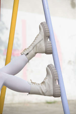 Female legs wearing white fashion boots with lacesの写真素材