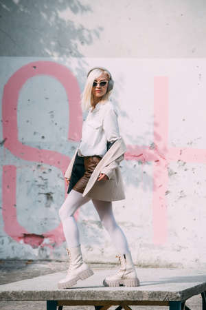 Portrait of blonde woman in headphones and sunglasses . Hipster fashion model wear stylish wireless headphones enjoy listen new cool music.の写真素材