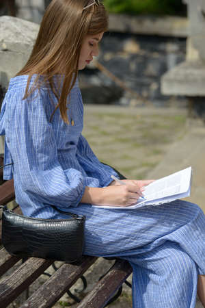 Female hand with pen completing personal information on form.の写真素材