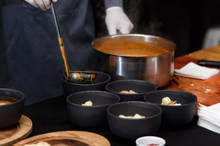 cooking process of Suquet de Peix soup with potatoes, herbs and fish with the addition of picada...