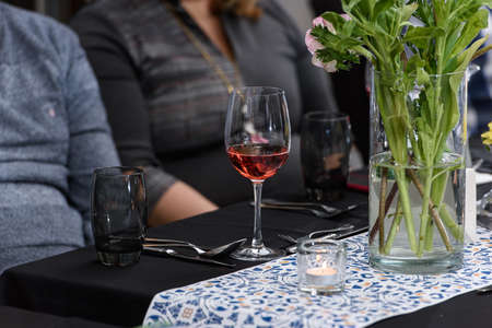 Glass of red wine on a served table in a restaurantの写真素材