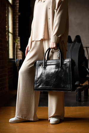 close-up photo of black leather bag in womans handの写真素材