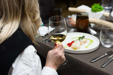 Young woman holding a glass of white wine