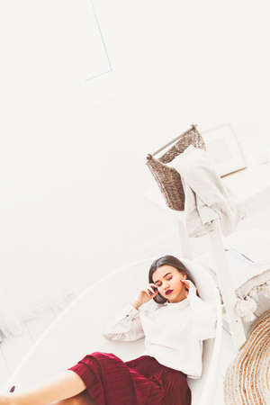 Portrait of fashionable women in red skirt and white blouse posing in a bathの写真素材
