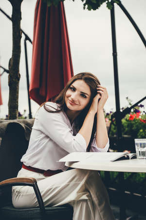 Smiling young dark-haired woman in a cafeの写真素材