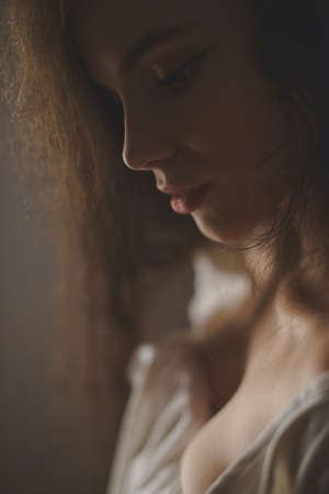 portrait of sexy young woman with very long curly hair seductively posing in studioの写真素材