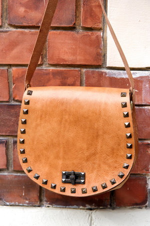 small yellow womens leather bag with rivets. selective focusの写真素材