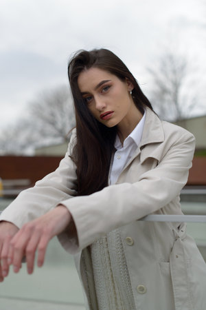 Outdoor portrait of a young beautiful fashionable lady wearing stylish coat . Model looking aside. Female fashion concept. City lifestyle. Close up.の写真素材
