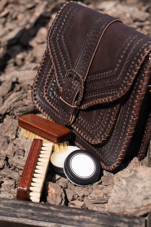 Wax and brush, leather maintenance concept. old genuine leather bag on a background.の写真素材